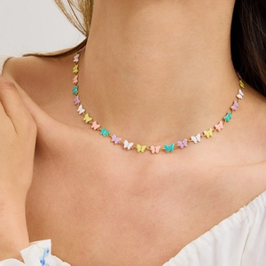 Colorful butterfly charm necklace in stainless steel displayed on female neck model