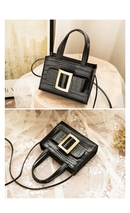 Detail of black crocodile texture handbag with golden buckle from front and top angles