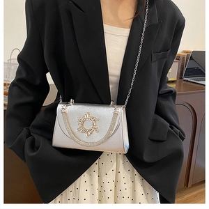 Silver crossbody square bag with sunburst crystal detail on an elegant chain strap