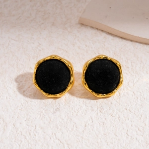 Detail of vintage gold-plated earrings with black flocked texture and irregular frame