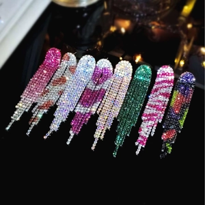 Macro display of eight pairs of luxury sparkling rhinestone tassel earrings in various colors