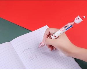 Detail of 6-color Christmas ballpoint pen with Santa Claus topper held while writing