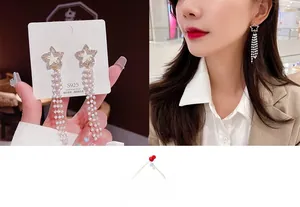Close-up of elegant star pearl tassel earrings with S925 silver needles on model
