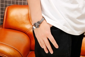 Detailed view of men's vintage lion head stainless steel bracelet worn on wrist