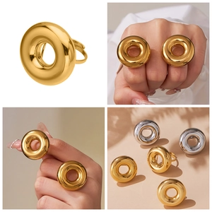 Detailed view of polished thick hollow donut ring in gold and silver finish on hand