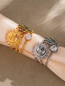 Macro detail of gold and silver sun cactus rings with green stones on silk