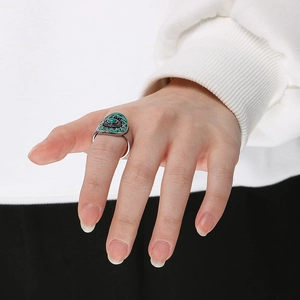 Detail of bohemian silver ring with oval turquoise stone and sun pattern on model hand