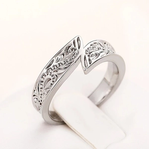 Close-up of retro feather ring with detailed floral vine carvings and antique finish