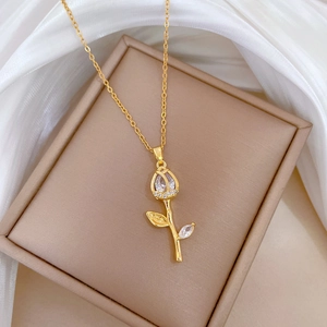 Detailed shot of a gold tulip pendant necklace with crystals on silk background
