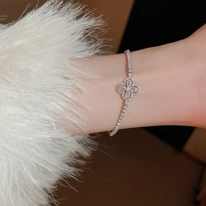 Gros plan détaillé d'un bracelet trèfle à quatre feuilles argenté avec zircons brillants
