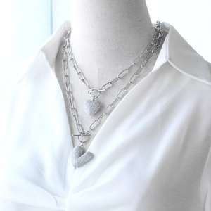 Silver paperclip layered necklace featuring two sparkling zircon heart pendants on a model