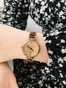 Detailed close-up of a vintage GEDI small gold dial watch with a brown leather strap