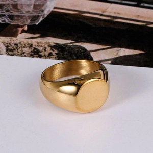 Polished gold titanium steel signet ring with a wide flat top surface on a white card
