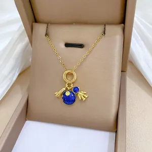 Detailed view of gold chain with astronaut, blue planet, and rocket charms on silk