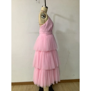Détail de robe rose en tulle à fleurs 3D avec jupon à volants étagés style gâteau