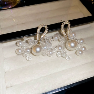 Detailed view of french pearl tassel earrings with zircons on a luxury display box