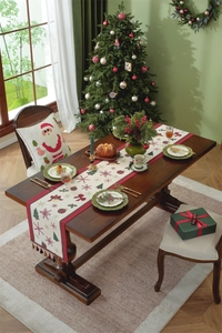 Christmas table runner with snowflakes and trees set on an elegantly decorated festive table