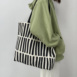 Detailed side view of high-density canvas tote with black and white geometric pattern