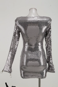 Détail du tissu à paillettes argentées et du zip circulaire sur une robe de soirée chic