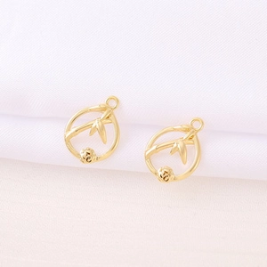 Detailed close-up of golden metal bamboo pattern pendants with zircon inlay craft