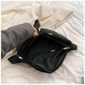 Top view detail showing interior compartments and zippers of a black nylon crossbody bag