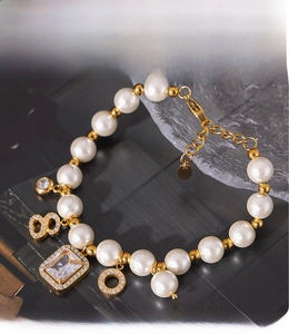 Macro detail of pearl bracelet with rectangular zircon pendant and PVD gold plating