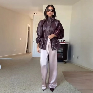 Deep burgundy leather jacket with drawstring waist paired with satin wide-leg trousers
