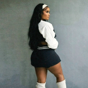 Rear side view of a women's black and white baseball sweatshirt and mini skirt set