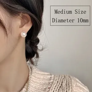 Close-up of a 10mm medium pearl stud earring shown on model with elegant styling
