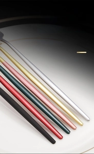 Detail view of colorful ergonomic handles on stainless steel cutlery set with matte finish