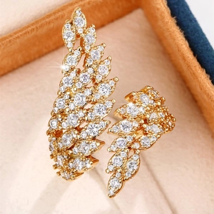 Macro shot of gold feather ring encrusted with zircon on a velvet jewelry box