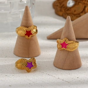 Close-up of three 18K gold-plated star rings with red, pink and purple enamel details