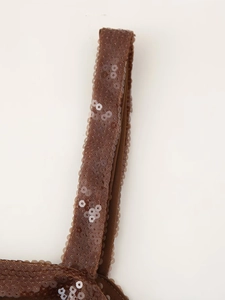 Macro detail of shimmering brown sequins and delicate stitching on backless party dress