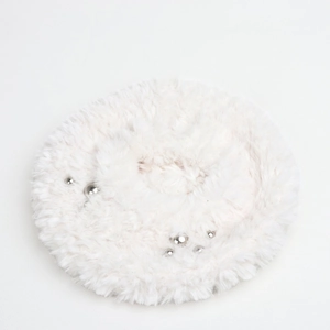 Detail of white faux fur beret hat featuring polished silver bead accents and soft texture
