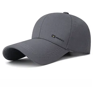 Detail of dark grey baseball cap with metal HEROISM logo and fine brim stitching
