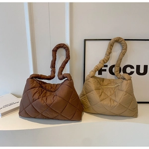 Detail showing large quilted patterns on dark brown and khaki puffer tote bags