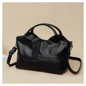 Detail view of black soft leather handbag showing PU texture and silver metal hardware