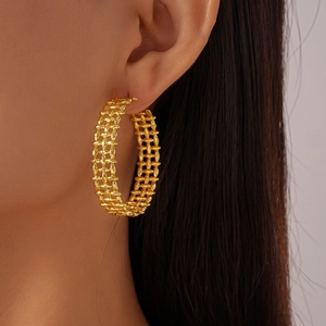 Detail view of 18K gold plated chunky hollow C-shaped earrings on a female model