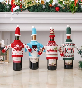 Detailed view of festive knitted wine bottle sweaters and hats with snowman and truck patterns