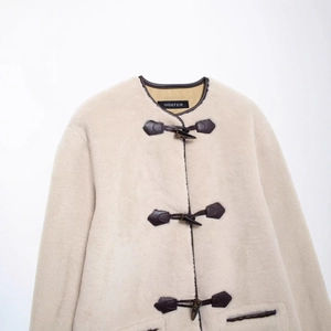 Manteau chic en fausse fourrure beige avec boucles en cuir marron et fermoirs brandebourg