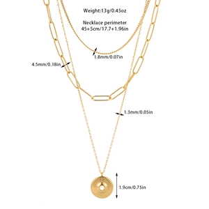 Detailed view of triple-layered golden steel necklaces with paperclip and sunburst pendant
