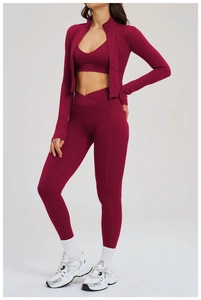 Detailed view of deep red three-piece workout set with cross-waist leggings and zip jacket