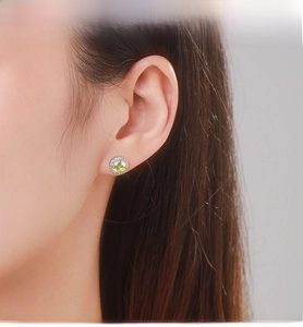 Close-up of S925 sterling silver stud earring featuring a bright yellow-green main stone