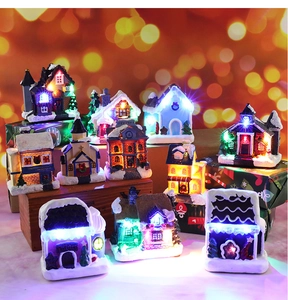 Close-up of lighted miniature resin Christmas house with warm festive bokeh background