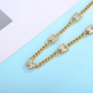 Detail of a gold Cuban link chain necklace featuring white butterfly shell pendants