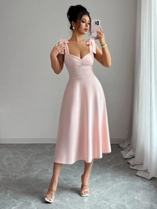 Roze nauwsluitende maxi-jurk met hartvormige hals en elegante strikbandjes op de schouders