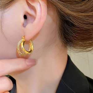 Macro detail of double hoop gold earrings with sparkling pavé cubic zirconia setting