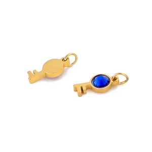 Detail view of two gold stainless steel key pendants, one with a blue gemstone inlay