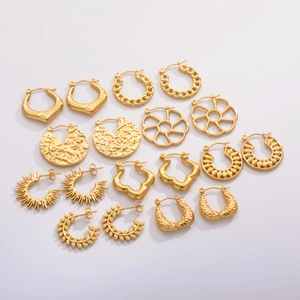 Flat lay of an 8-piece gold earring set with woven, floral, and textured metal designs