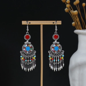 Detailed macro view of Bohemian tassel earrings with colorful beads on a display stand
